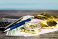 Composition of a tourist compass, banknotes, coins, calculator and pen on the background of the sea