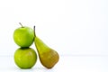 The composition of two fresh green apples and one long pear on white background Royalty Free Stock Photo