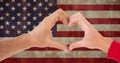 Composition of two hands making heart shape over american stars and stripes flag Royalty Free Stock Photo