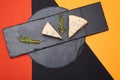 Composition of two piece of blue cheese and rosemary on black slate on abstract colored background Royalty Free Stock Photo