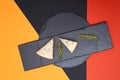 Composition of two piece of blue cheese and rosemary on black slate on abstract colored background Royalty Free Stock Photo