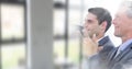 Composition of two successful caucasian businessmen smiling and clapping over blurred office