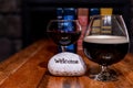 Composition of two vine glasses, books and a stone with `Welcome` word on it