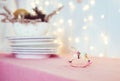 Composition with vintage Christmas tree toy porcelain figurine of a rocking horse and dishes on the pink table on the background Royalty Free Stock Photo