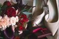 Composition from a wedding bouquet of white and red roses with gold rings with topaz, beige bride shoes and boxes Royalty Free Stock Photo