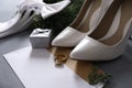 Composition with wedding rings, white high heel shoes and decor on grey background Royalty Free Stock Photo