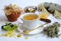 Composition on a white background. A cup of herbal tea, honey, linden flowers, chamomile and thyme. Concept of healthy Royalty Free Stock Photo