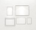 Composition of white blank picture frames on white brick wall with spotlights Royalty Free Stock Photo