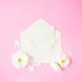 Composition with white flowers, petals and vintage envelope on pink background. Flat lay, top view. Vintage background Royalty Free Stock Photo