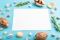 Composition with white paper sheet, seashells, green boxwood. mockup on blue pastel background. side view, copy space