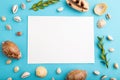 Composition with white paper sheet, seashells, green boxwood. mockup on blue pastel background. top view, copy space