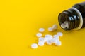 Composition close up white pills with bottle on yellow background with blank space for text. Royalty Free Stock Photo