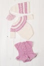 Composition of white-pink knitted suit and hat Royalty Free Stock Photo