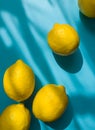 Composition with whole ripe yellow lemons on bright blue background. Summer time flat lay with daylight and sharp shadows. Top