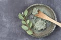 Essential oil with cosmetic clay and cornflower and branch of eucalyptus, stones, for spa treatments, in wood spoon, on