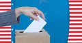 Composition of woman casting vote into ballot box against american flag Royalty Free Stock Photo