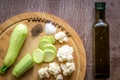 Composition on wooden background organic vegetarian foods: zucchini, cauliflower, black pepper and salt. The view from