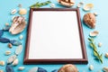 Composition with wooden frame, seashells, green boxwood. mockup on blue pastel background. side view, copy space