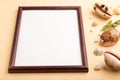 Composition with wooden frame, seashells, green boxwood. mockup on orange background. side view, copy space