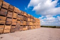 Composition of wooden pallets and boxes on the background of a cloudy sky in a warehouse near an agroindustrial hangar Royalty Free Stock Photo