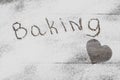 Composition with word BAKING and heart made with flour on wooden table Royalty Free Stock Photo