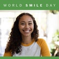 Composition of world smile day text over biracial woman smiling on green background Royalty Free Stock Photo
