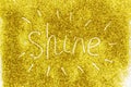 A composition with written a word shine on beautiful gold glitter. Background and texture of gold glitter. Luxury gold glitter