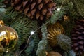 Composition of Xmas toys cones and branches of spruce. Glowing garland. Close-up Royalty Free Stock Photo