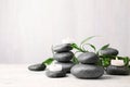 Composition with zen stones, bamboo and lighted candles on table against light background Royalty Free Stock Photo