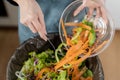 Compost the kitchen waste, recycling, organic meal asian young household woman scraping, throwing food leftovers into the garbage Royalty Free Stock Photo