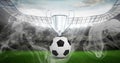 Compostion of cup and football over stadium and white smoke Royalty Free Stock Photo