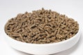 Compound feed for rabbits in a plate on a white background. Rabbit food, balanced pet food. Meals for meat rabbits