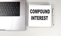 COMPOUND INTEREST text on notebook with laptop and pen Royalty Free Stock Photo
