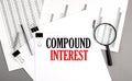 COMPOUND INTEREST text on paper on chart background Royalty Free Stock Photo