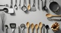 Collection of various kitchen utensils including spoons, spatulas, whisks, tongs, and a frying pan arranged against a neutral Royalty Free Stock Photo