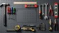 Assortment of hand tools neatly organized on a dark grey pegboard, showcasing various equipment for home improvement and repair Royalty Free Stock Photo