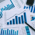 Comprehensive financial data analysis desk with blue and white bar graphs and numerical data. Royalty Free Stock Photo