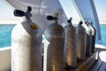 Compressed air tanks for scuba diving are lined up in row on pleasure yacht. View on background of blue sea. Copy space. Close-up