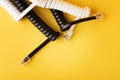 Compressed black and white spiral phone cord with connectors on yellow background Royalty Free Stock Photo