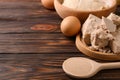 Compressed and dry granulated yeast, eggs and dough on wooden table, space for text