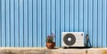 Compressor air-conditioner and Flower Pot on zinc wall Royalty Free Stock Photo