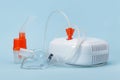 Compressor inhaler, respiratory masks and atomizing cup on blue background