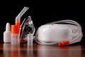 Compressor nebulizer and respiratory mask for on table against dark background