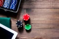 Compulsive gambling. Poker chips and the dice nearby tablet on wooden table top view copyspace