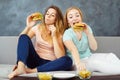 Two young women greedily eating burgers and chips Royalty Free Stock Photo
