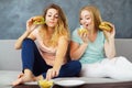 Two young women greedily eating burgers and chips Royalty Free Stock Photo