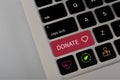 A computer button with the text DONATE. The concept of spread awareness and encourage donations for health, those in need, and