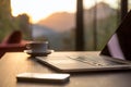 Computer Coffee Mug and Telephone on black wood table sun rising Royalty Free Stock Photo