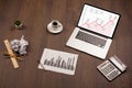 Computer desk with laptop and red arrow chart in screen Royalty Free Stock Photo