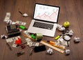 Computer desk with laptop and red arrow chart in screen Royalty Free Stock Photo